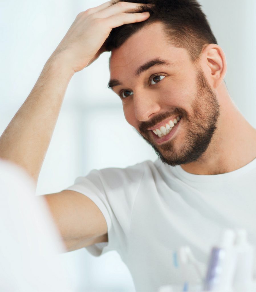 Man checking for hair loss on his scalp