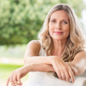 Middle age woman with blonde hair sitting outside