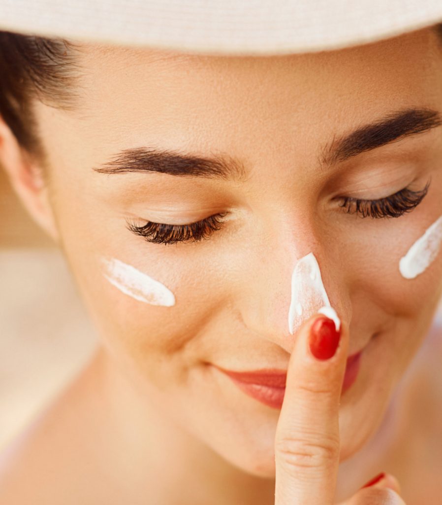 Woman applying sunscreen to her face