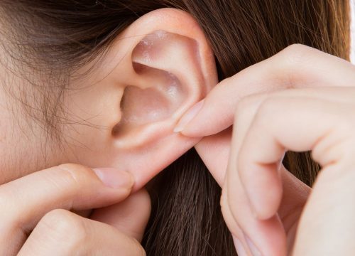 Woman tugging on a torn earlobe