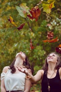 Two women watching leaves fall