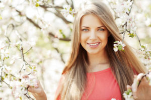 Woman standing next to cherry blossoms