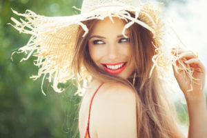 Woman wearing a straw hat and red lipstick