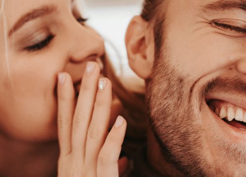 Woman whispering in a man's ear after torn earlobe repair