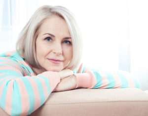 Older woman leaning on her couch