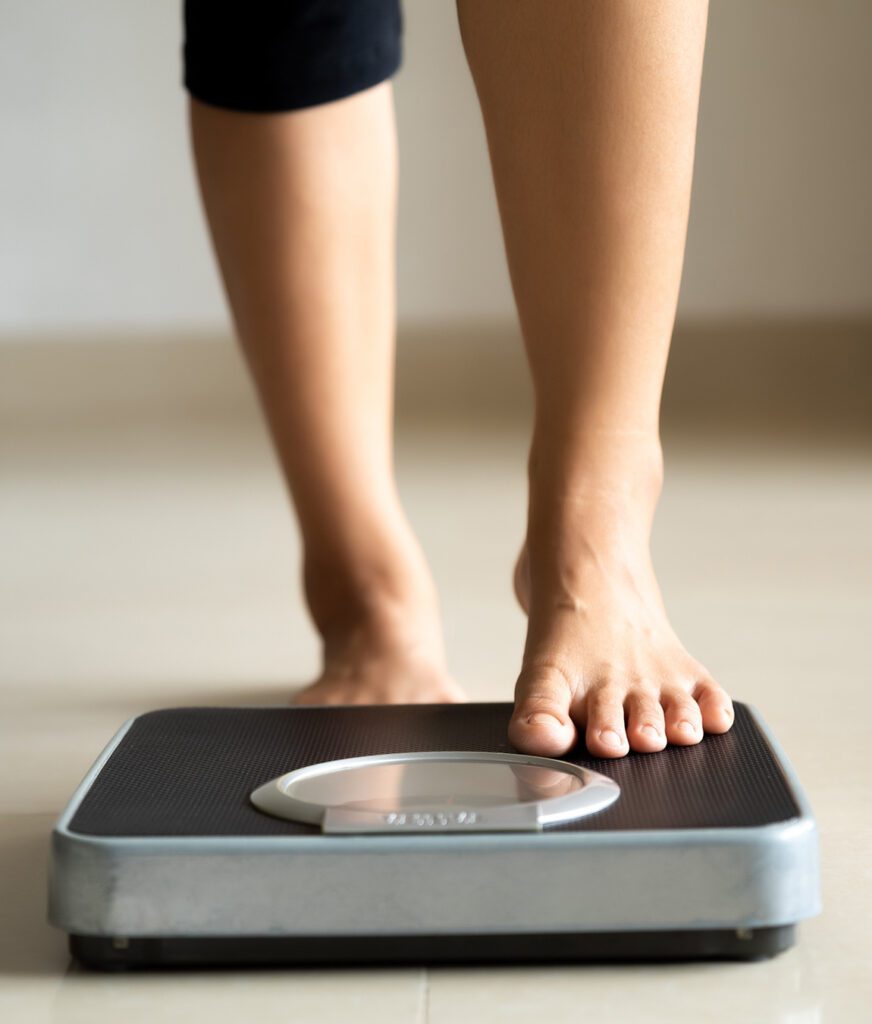 Photo of a woman's feet stepping onto a scale